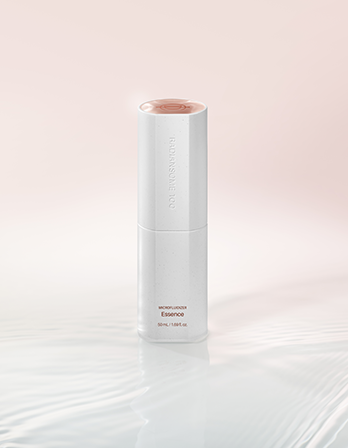 White skincare bottle labeled 'Essence' on a light pink background